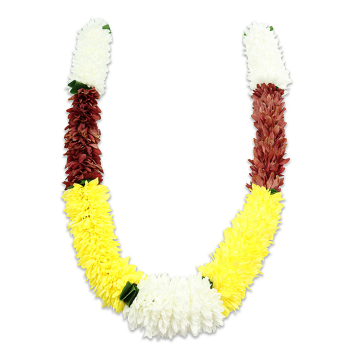 Displayed against a stark white background, this U-shaped traditional floral garland shows meticulous craftsmanship in every tightly packed petal. The composition is intentionally segmented: each arm opens with a dense cream-white section of small, chrysanthemum-like petals that creates a serene header, followed by a compact band of maroon or reddish-brown that adds weight and visual contrast. The longest, most emphatic stretch is a plush line of sunny yellow clusters-bright, rounded, and voluminous-that sweeps along the lower curve and commands attention. At the nadir of the 'U' the two yellow arcs converge into a substantial, central cluster of pure white flowers which serves as the focal point, while small dark green leaf accents are used sparingly between colour blocks to sharpen transitions and suggest living greenery. The garland is constructed from high-quality fabric blooms and soft yarn cores; when viewed closely you can appreciate the thousands of individual petals layered and stitched to mimic natural floral anatomy, providing both durability and a convincing tactile impression. Commonly described as a mala in South Asian practice, this type of garland is used for puja, temple offerings, weddings and festivals such as Diwali and Holi, where its colour language-white for purity, yellow for prosperity, maroon for devotion-carries emotional and cultural resonance. As a decorative object it reads equally well in a domestic shrine, a temple doorway, or as a ceremonial presentation at local gatherings around Maidenhead Market or the arts events at Norden Farm.