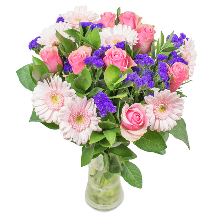 An exquisite bouquet artfully presented in a crystal-clear glass vase, posed against a softly illuminated white background and expertly arranged by Maidenhead's local florists. At its heart, approximately seven to nine pale to rich pink roses display a spectrum of beauty-from buds still gently curled to blooms opening in perfect spiral formation-evoking both youthful anticipation and blossoming love. These romantic roses are woven with five to seven Gerbera daisies, whose generous, rounded petals span hues of pale blush, their centers tinged almost white, contributing airy charm and sunlit freshness. Scattered throughout the design, vividly purple statice offers a lively pop of color and intriguing texture, echoing the playful energy of town center markets or the River Thames during a festival. Robust dark green foliage frames and anchors the arrangement, infusing it with abundant vitality and the lush scent of English gardens. Visible through the transparent vase, each stem and the freshness of the water underscore the bouquet's just-picked vibrancy. This radiant medley-roses, gerberas, and purple accent blooms-captures the spirit of Maidenhead, making it an ideal choice for birthdays, anniversaries, Mother's Day, or to bring a refined, affectionate touch to home or office. The arrangement expresses celebration, warmth, and the unique local artistry nurtured by Flower Delivery Maidenhead.